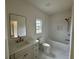Bright bathroom with white cabinets, marble floors, and shower-tub combo at 5753 Brendlynn Dr, Suwanee, GA 30024