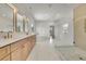 Luxurious bathroom with dual vanity, a freestanding tub, marble floors, and a glass-enclosed shower at 5753 Brendlynn Dr, Suwanee, GA 30024