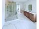 This bathroom has white marble floors, a glass shower, and a long vanity with double sinks at 5753 Brendlynn Dr, Suwanee, GA 30024