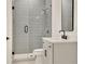 Modern bathroom features a glass shower and a white vanity with black fixtures at 5753 Brendlynn Dr, Suwanee, GA 30024