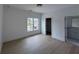 This bedroom has hardwood floors, white walls, and a large window with natural light at 5753 Brendlynn Dr, Suwanee, GA 30024