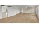 Bright bedroom with white walls, light wood floors, barn door, and modern chandelier at 5753 Brendlynn Dr, Suwanee, GA 30024