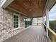 A covered deck features wood ceiling, brick pillars, and scenic backyard views at 5753 Brendlynn Dr, Suwanee, GA 30024