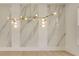 Close-up of the dining room's elegant chandelier and decorative marble wall at 5753 Brendlynn Dr, Suwanee, GA 30024
