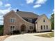 Stunning two-story home with brick and stone and arched entryway at 5753 Brendlynn Dr, Suwanee, GA 30024