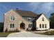 Stunning new construction home with brick and stone accents, complemented by a meticulously landscaped front yard at 5753 Brendlynn Dr, Suwanee, GA 30024