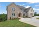 Stunning two-story brick home with a manicured lawn, showcasing elegant architecture and inviting curb appeal at 5753 Brendlynn Dr, Suwanee, GA 30024