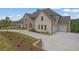 Beautiful two-story home with stone and brick exterior, complemented by a spacious driveway and lush landscaping at 5753 Brendlynn Dr, Suwanee, GA 30024