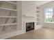 Cozy fireplace with built-in shelves and marble accents at 5753 Brendlynn Dr, Suwanee, GA 30024