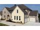 Beautiful new construction home featuring a blend of brick and stone, with a three-car garage at 5753 Brendlynn Dr, Suwanee, GA 30024