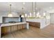 Open concept kitchen with a large island, modern lighting, and stainless steel appliances at 5753 Brendlynn Dr, Suwanee, GA 30024