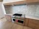 Close up of range area in kitchen with white marble backsplash and stainless appliances at 5753 Brendlynn Dr, Suwanee, GA 30024