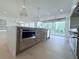Modern kitchen with stainless steel appliances, spacious island with sink, and sliding doors to outdoor space at 5753 Brendlynn Dr, Suwanee, GA 30024