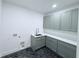 Laundry room featuring gray cabinets, sleek countertops, and stylish herringbone floors at 5753 Brendlynn Dr, Suwanee, GA 30024