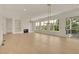 Bright living room with fireplace, built-in shelving, hardwood floors and large windows with outdoor views at 5753 Brendlynn Dr, Suwanee, GA 30024
