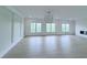 Bright living room featuring hardwood floors, three large windows, and a modern chandelier at 5753 Brendlynn Dr, Suwanee, GA 30024