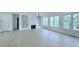 Spacious living room with hardwood floors, fireplace, built-in shelving, and large windows with a view of outdoors at 5753 Brendlynn Dr, Suwanee, GA 30024