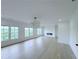 Bright living room featuring hardwood floors, three large windows, and a modern fireplace at 5753 Brendlynn Dr, Suwanee, GA 30024