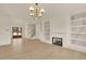 Bright living room with a fireplace, built-in shelving, and stylish chandelier at 5753 Brendlynn Dr, Suwanee, GA 30024