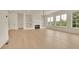 Spacious living room with a fireplace, built-in shelves, and large windows at 5753 Brendlynn Dr, Suwanee, GA 30024