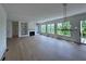 Open living room featuring built-in bookshelves, a fireplace, and expansive windows overlooking the landscape at 5753 Brendlynn Dr, Suwanee, GA 30024