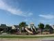 Community playground featuring a slide and play structure surrounded by green space and mature trees at 5753 Brendlynn Dr, Suwanee, GA 30024