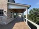 Relaxing porch with wooden ceiling, brick exterior, and black metal railings at 5753 Brendlynn Dr, Suwanee, GA 30024