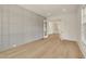Spacious room with modern wall paneling, light hardwood floors, and glass doors at 5753 Brendlynn Dr, Suwanee, GA 30024