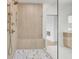 Spa-like shower with vertical wood-like tile, gold fixtures, and a built-in bench seat at 5753 Brendlynn Dr, Suwanee, GA 30024