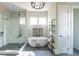 Modern bathroom featuring a soaking tub, glass shower, decorative fixtures, and ample natural light at 225 Blueberry Rdg, Milton, GA 30075