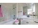 Modern bathroom with glass enclosed shower over tub, bright marble tile and black fixtures at 225 Blueberry Rdg, Milton, GA 30075