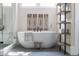 A sleek bathroom featuring a modern soaking tub, decorative wall art, and stylish shelving, creating a spa-like retreat at 225 Blueberry Rdg, Milton, GA 30075