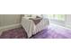 Bright bedroom featuring white linens, neutral walls, and a striking purple patterned rug at 225 Blueberry Rdg, Milton, GA 30075