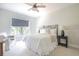 Calm bedroom with large window, cozy chair, ceiling fan, and neutral decor at 225 Blueberry Rdg, Milton, GA 30075