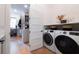 Bright laundry room with front loading washer and dryer, a folding counter, and access to a closet at 225 Blueberry Rdg, Milton, GA 30075