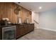 Stylish wet bar featuring a wood accent wall, pendant lighting, and stainless refrigerator at 225 Blueberry Rdg, Milton, GA 30075