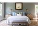 This main bedroom features a large bed with side tables, a bench, and a soft accent rug at 225 Blueberry Rdg, Milton, GA 30075