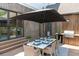 Inviting outdoor dining area with a table, chairs, umbrella, and built-in grill at 225 Blueberry Rdg, Milton, GA 30075