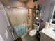 Bathroom featuring shower with glass door, toilet, and shelving unit at 2539 Dogwood Hills Ct, Austell, GA 30106