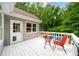 Back porch with a view of the swimming pool, lush green trees, and outdoor seating at 320 Williamsburg Cir, Mcdonough, GA 30253