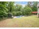 Large backyard with an in-ground pool, mature trees, and a covered structure at 320 Williamsburg Cir, Mcdonough, GA 30253