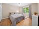 Bedroom featuring a queen bed, hardwood floors, a window, and neutral paint at 320 Williamsburg Cir, Mcdonough, GA 30253