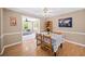 Dining room with hardwood floors, a table with 4 chairs, and an adjacent sunroom at 320 Williamsburg Cir, Mcdonough, GA 30253
