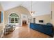 Bright and airy living room features vaulted ceiling, arched windows, fireplace, and hardwood floors at 320 Williamsburg Cir, Mcdonough, GA 30253
