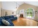 Light-filled living room with vaulted ceiling, brick fireplace and large arched windows overlooking a lush backyard at 320 Williamsburg Cir, Mcdonough, GA 30253