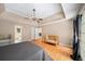 Spacious main bedroom with tray ceilings, hardwood flooring, and ample natural light at 320 Williamsburg Cir, Mcdonough, GA 30253