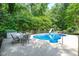 In-ground pool with a slide and an outdoor dining set on a concrete patio at 320 Williamsburg Cir, Mcdonough, GA 30253