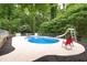 In-ground pool with a slide and deck surrounded by a fence and mature trees at 320 Williamsburg Cir, Mcdonough, GA 30253