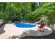 An in-ground pool with a slide and chairs surrounded by mature trees at 320 Williamsburg Cir, Mcdonough, GA 30253