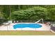 In-ground pool with a slide, surrounded by chairs and mature trees at 320 Williamsburg Cir, Mcdonough, GA 30253